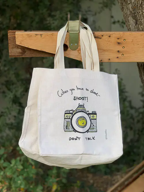 תיק בד עם ציור של מצלמה וינטג' וכיתוב: When you have to shoot – shoot! Don't talk